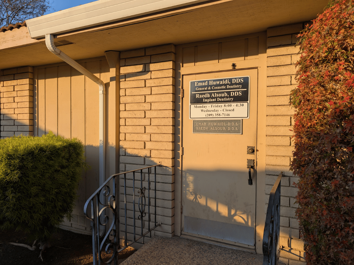 Dental clinic entrance with name placard and business hours