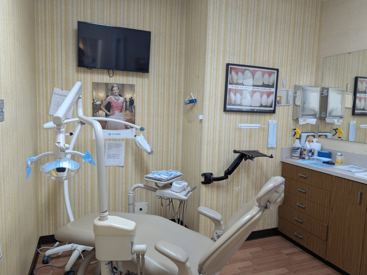 Modern dental treatment room with equipment and TV